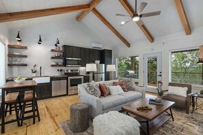 A spacious kitchen with modern appliances, a dining area with wooden furniture, and a cozy seating area with a sofa and armchairs.