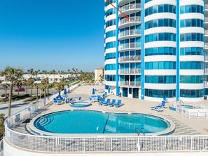 Relax by the pool surrounded by comfortable lounge chairs and umbrellas.