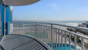 Un balcon avec vue sur la plage et l’océan.