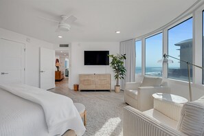 Relax in this serene bedroom with a large bed, flat-screen TV, and ocean views.