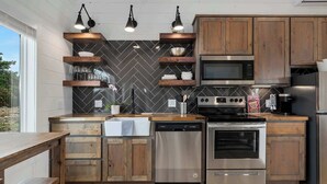A modern kitchen with wooden cabinets, a dishwasher, a stove, and a microwave.