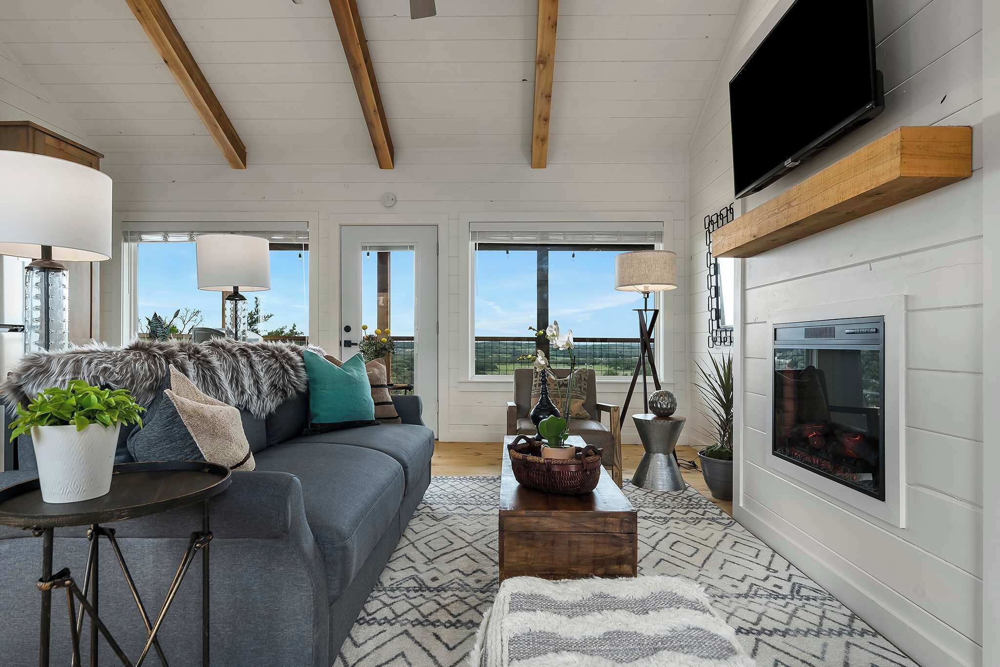 A living room with a sofa, coffee table, lamps, and a fireplace.
