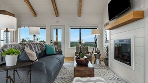 A living room with a sofa, coffee table, lamps, and a fireplace.