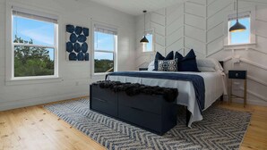 A bedroom with a bed, a dresser, two windows, and a ceiling fan. - Modern Ranch Retreat with Hill Country Views (Gillespie County)