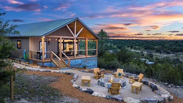 A cabin with a deck, outdoor seating, and a fire pit. - Modern Ranch Retreat with Hill Country Views (Gillespie County)
