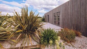 A modern building with a wooden facade and a gravel pathway. - Les Villas du Parc de la Chabotterie (Montréverd)