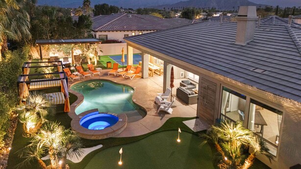Una propiedad residencial con piscina, mobiliario de exterior y vistas a las montañas.