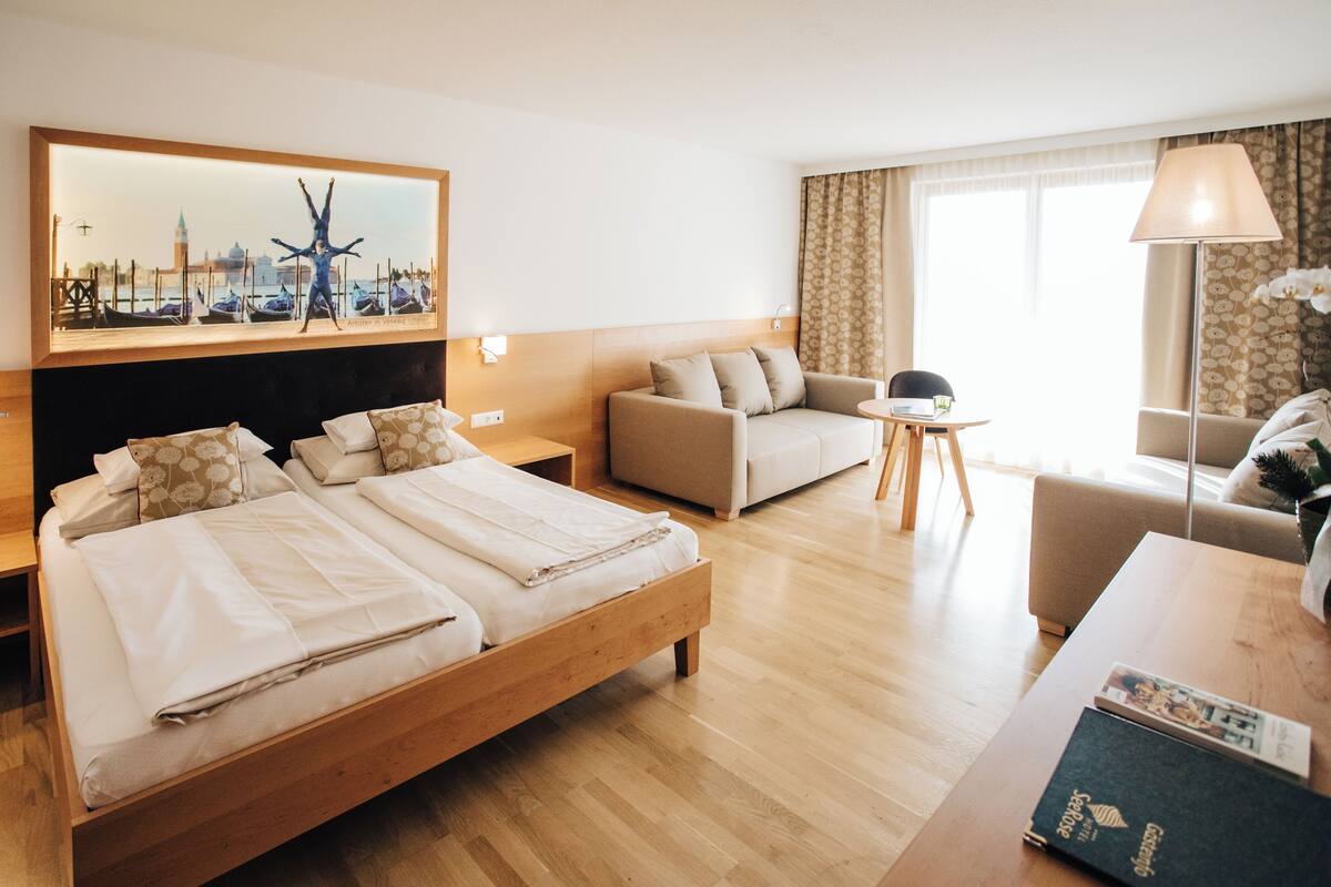 Ein Hotelzimmer mit einem Bett, einer Couch, einem kleinen Tisch und einer Lampe.