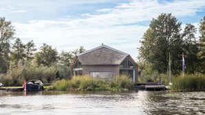 A house with a sloped roof, surrounded by water and trees. - 3 bedroom lovely home in Warten (Warten)