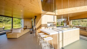 A modern kitchen with a central island, bar stools, and a built-in stove. - 3 bedroom lovely home in Warten (Warten)