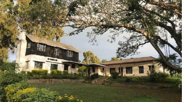 A two-story house with a large front lawn and a tree in the foreground. - Uncle Bob's Farm Hotel Nyeri/Nanyuki (Nairobi)