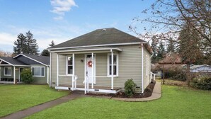 A single-story house with a front porch, a small front yard, and a mailbox. - Pet-friendly 1917 Art Deco 2BR in Olympia, walkable downtown with workspace, parking, and modern comfort (Olympia)