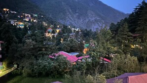 A mountainous landscape with houses nestled among trees. - Gagan Resort (Dharamshala)