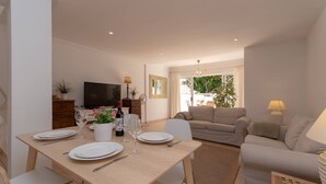 A modern living room with a dining area, a sofa, and a TV. - Palms 4 - Three Bed S (Golf del Sur)
