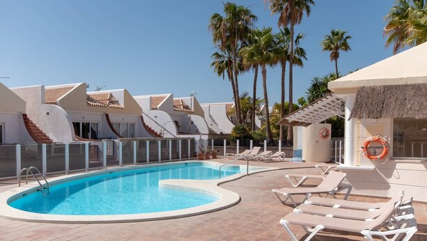 A swimming pool with lounge chairs and palm trees. - Palms 4 - Three Bed S (Golf del Sur)