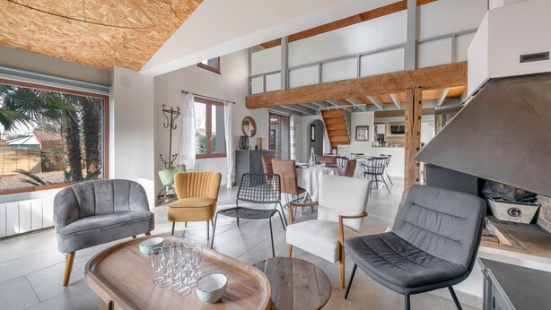 A modern dining area with a wooden table, several chairs, and a view of the outdoors. - House with an extension for 11 at 800m from the sea (La Plaine-sur-Mer)