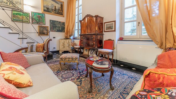 A room with a sofa, ottoman, wooden cabinet, and a patterned rug. - Portello Apartment By Geco Vacation Rentals (Genoa)