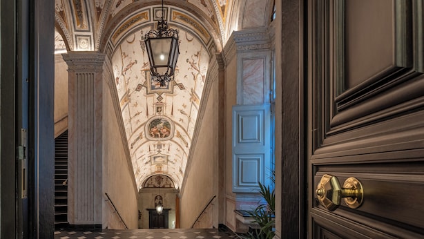 A grand hallway with a checkered floor, ornate ceiling, and a large door with a brass handle. - Portello Apartment By Geco Vacation Rentals (Genoa)