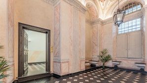 A lobby with a checkered floor, marble walls, and a large door. - Portello Apartment By Geco Vacation Rentals (Genoa)