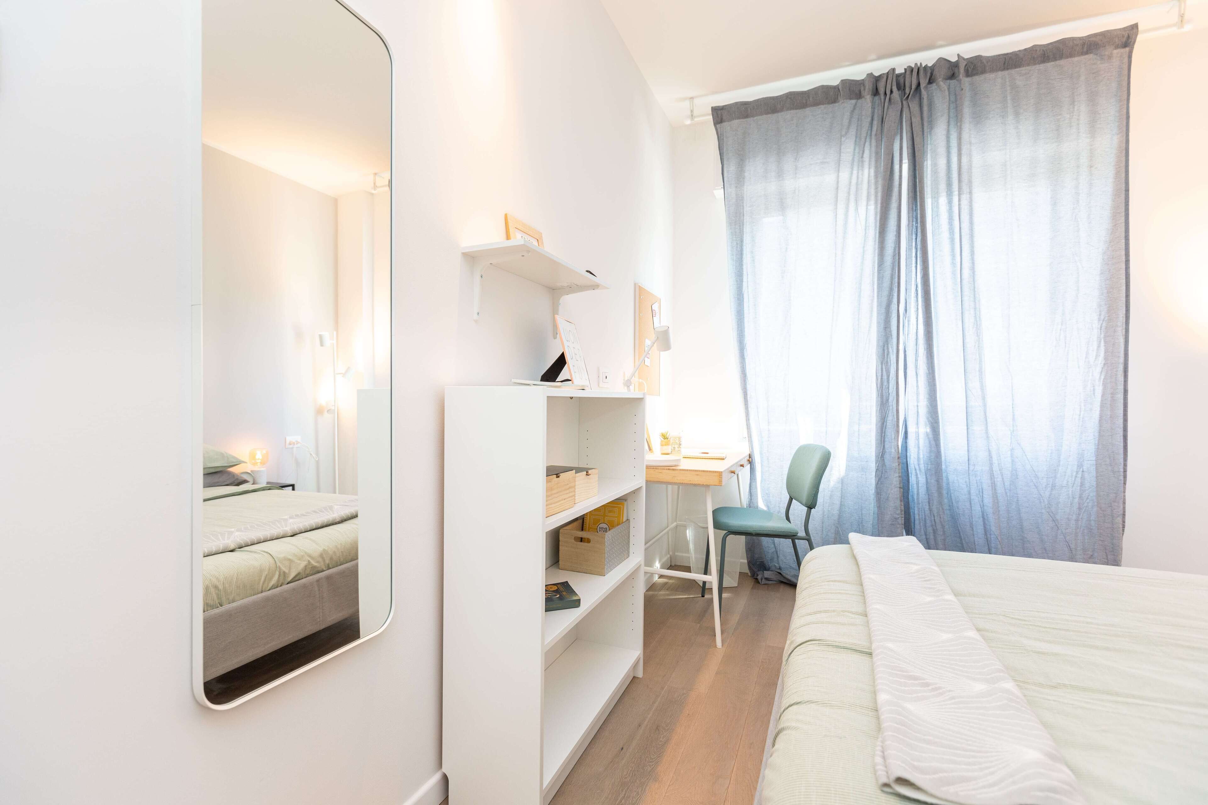Une chambre bien rangée, avec un lit, un bureau, une chaise et une armoire.