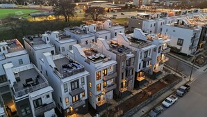 Un immeuble d’appartements moderne, doté de plusieurs étages, de balcons et d’espaces extérieurs aménagés pour se détendre.
