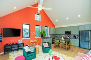 A modern living space with a kitchen, dining area, and entertainment setup. - Livin' Luxe on Music Row | Hot Tub & 1mi to DT (Nashville)