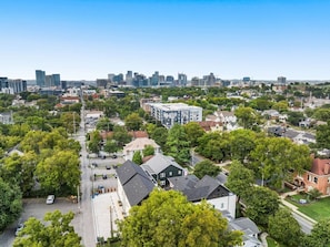 Vista aérea de una zona residencial con una mezcla de edificios modernos y tradicionales, rodeada de vegetación.