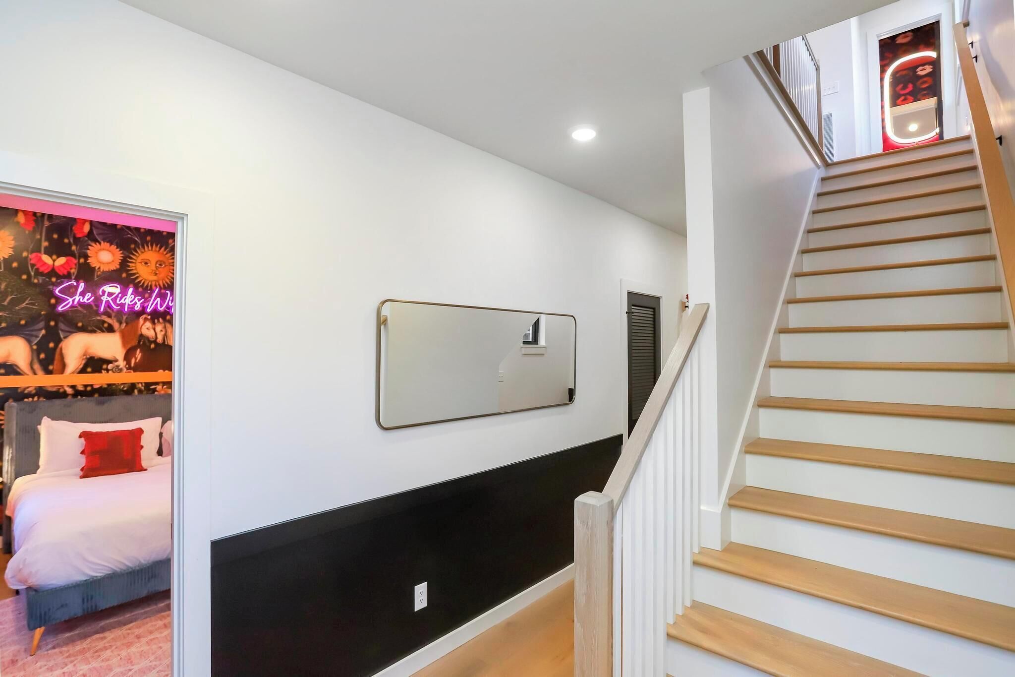 Ein Schlafzimmer mit Bett, Spiegel und Treppe.