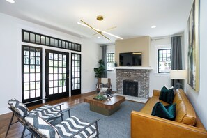 A modern living room with a fireplace, a television, and a seating area with a coffee table.