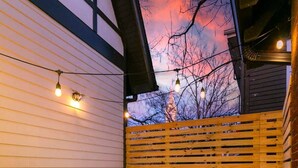 A hot tub in an outdoor setting with a wooden deck and a wooden fence. - Chic Belmont Retreat | Hot Tub, 5 King Beds, Walk to 12S (Nashville)