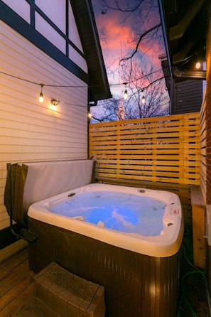 A hot tub in an outdoor setting with a wooden deck and a wooden fence. - Chic Belmont Retreat | Hot Tub, 5 King Beds, Walk to 12S (Nashville)