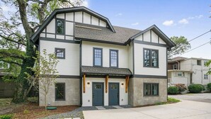 A two-story house with a front porch, a garage, and a driveway. - Belmont Luxe | Walk to Hillsboro, Belmont & 12 So (Nashville)