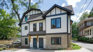 A two-story house with a front porch, a garage, and a driveway. - Chic Belmont Retreat | Walk to Hillsboro & 12 South (Nashville)