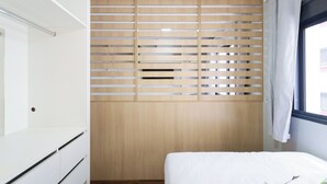 Una camera da letto con un letto, un armadio a ribadi e una finestra con tende.