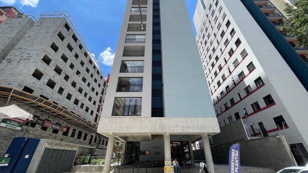 Un edificio a più piani con un ingresso centrale, balconi e una insegna che indica che si tratta di un hotel.