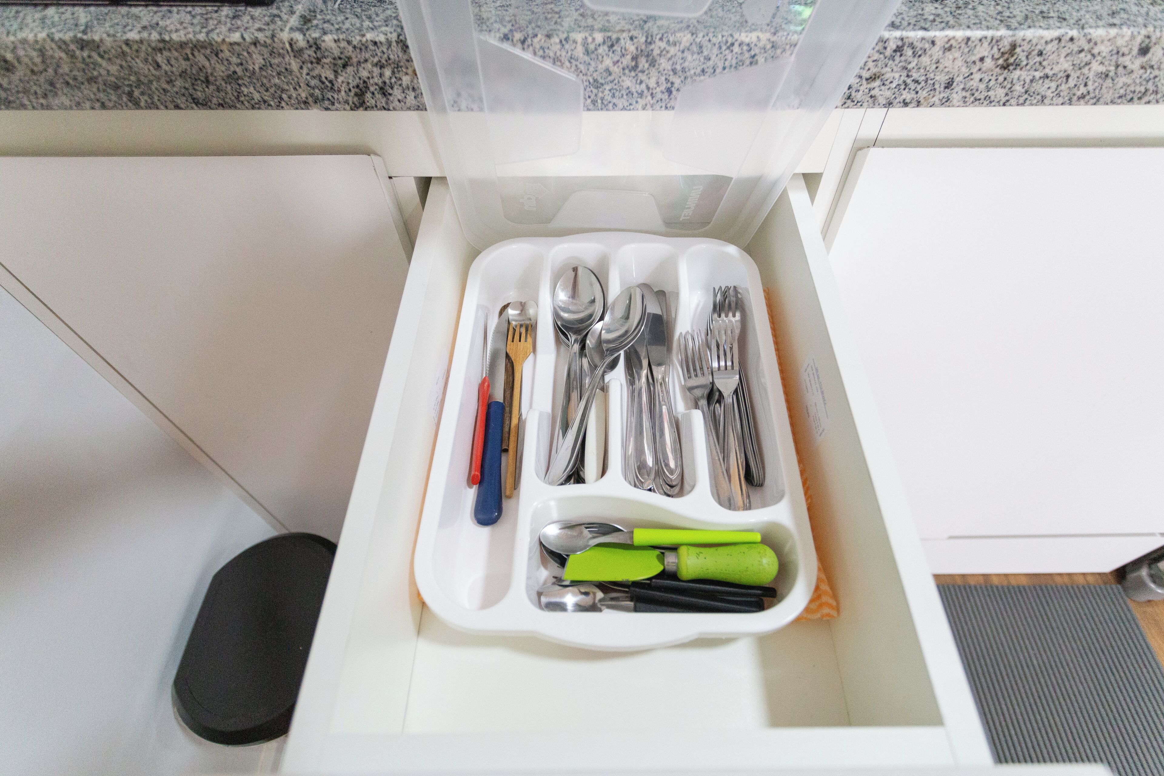 A drawer with a utensil organizer containing forks, spoons, knives, and spatulas.