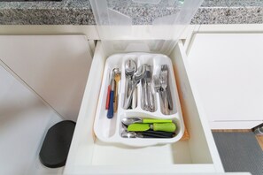 A drawer with a utensil organizer containing forks, spoons, knives, and spatulas. - Bem Viver Praça Buarque (Sao Paulo)