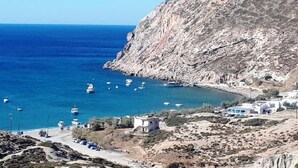 Eine Küstenlandschaft mit felsigem Gelände, tiefblauem Meer und mehreren Booten.