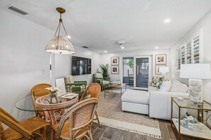 A living room with wicker furniture, a white sofa, a glass table, and a ceiling fan. - Royal Palm Retreat - 1123-25   “Siesta Key” (Sarasota)