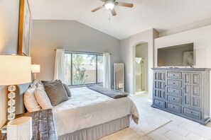 Relax in this serene bedroom with a large bed, ceiling fan, and flat-screen TV.