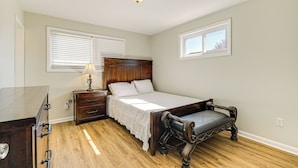 Un dormitorio con una cama de madera, un aparador y una mesita de noche.