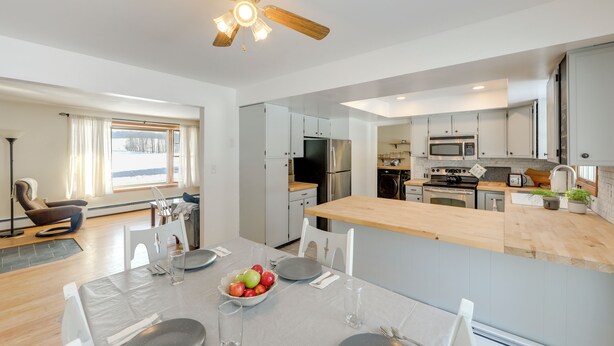 A modern kitchen with white cabinets, stainless steel appliances, and a wooden island. - Deck & Fire Pit: Cozy Escape in Morrisville! (Morrisville)