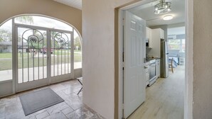 A spacious room with a large sliding glass door leading to a patio, a kitchenette, and a view of the outdoors. - 5 Mi to Beaches: Melbourne Duplex w/ Heated Pool! (Melbourne)