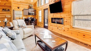 Un interior acogedor de cabaña con sala de estar, comedor y cocina.