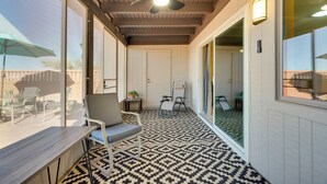 A covered patio area with a ceiling fan, a table, and two chairs. - Tranquil Green Valley Home w/ Screened Porch (Green Valley)