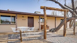 A building with a 'Welcome' sign, outdoor seating, and a tree in the foreground. - Patio & Mtn Views: Wickenburg 'trail Head House' (Wickenburg)