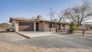A single-story house with a garage, a small porch, and a gravel driveway. - Patio & Mtn Views: Wickenburg 'trail Head House' (Wickenburg)
