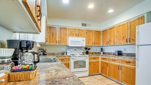 A kitchen with wooden cabinets, a white stove, a microwave, and a refrigerator. - Patio & Mtn Views: Wickenburg 'trail Head House' (Wickenburg)