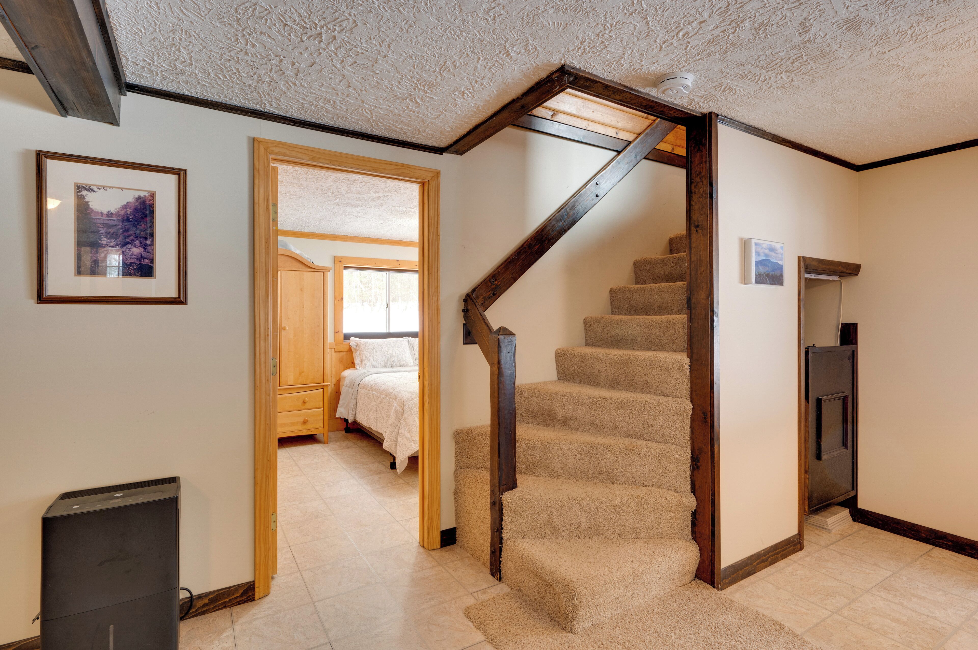 A staircase leading to a bedroom with a wooden door and a framed picture on the wall.