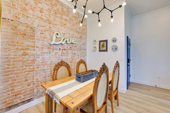 Un coin repas avec un mur en briques, une table en bois et des chaises.